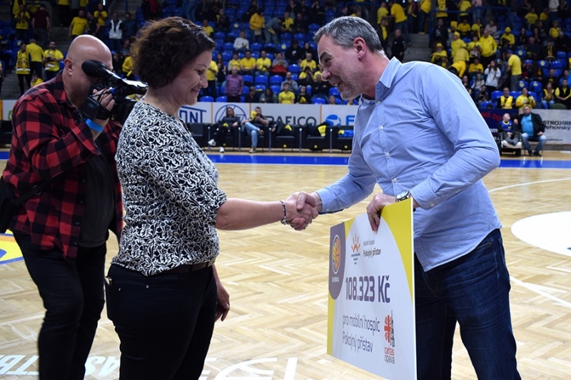 Šek za dražbu dresů předali basketbalisté hospici na palubovce